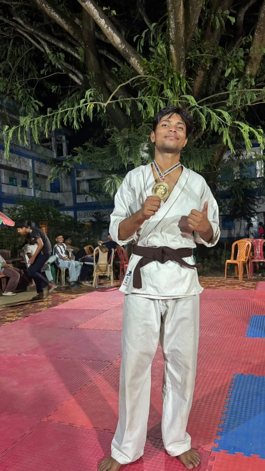 Karate participant holding a medal after an event
